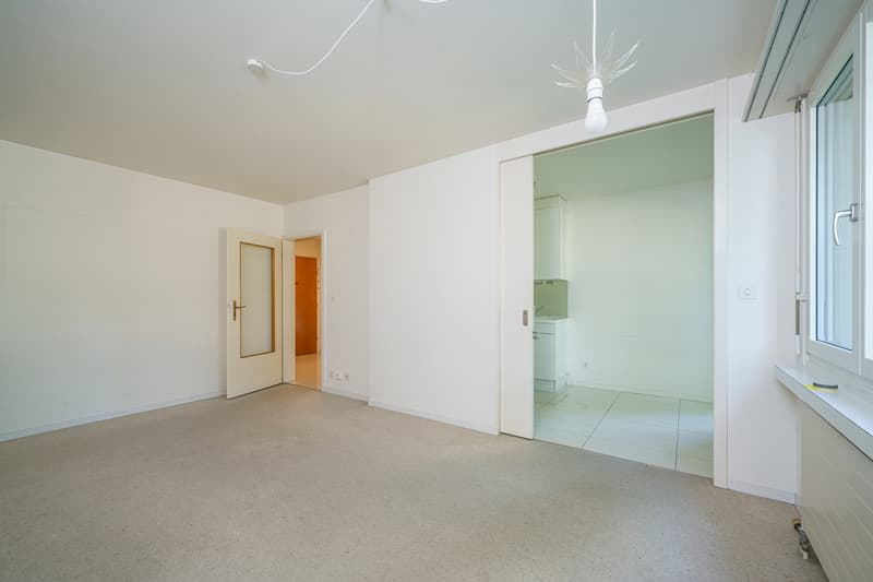 ein leerer Raum in einem Haus mit einem großen Fenster / an empty room in a home with a large window
