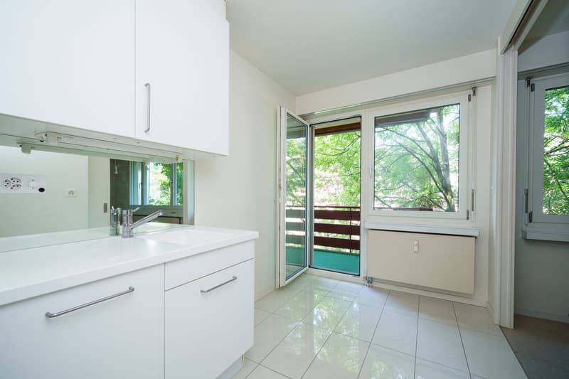 ein modernes Badezimmer mit weißen Schränken, einem großen Fenster und einer Glasschiebetür zu einem anderen Raum / a modern bathroom with white cabinets, a large window and a sliding glass door t