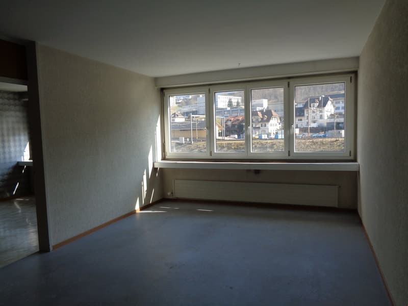 empty room with a large window and a heater below the window