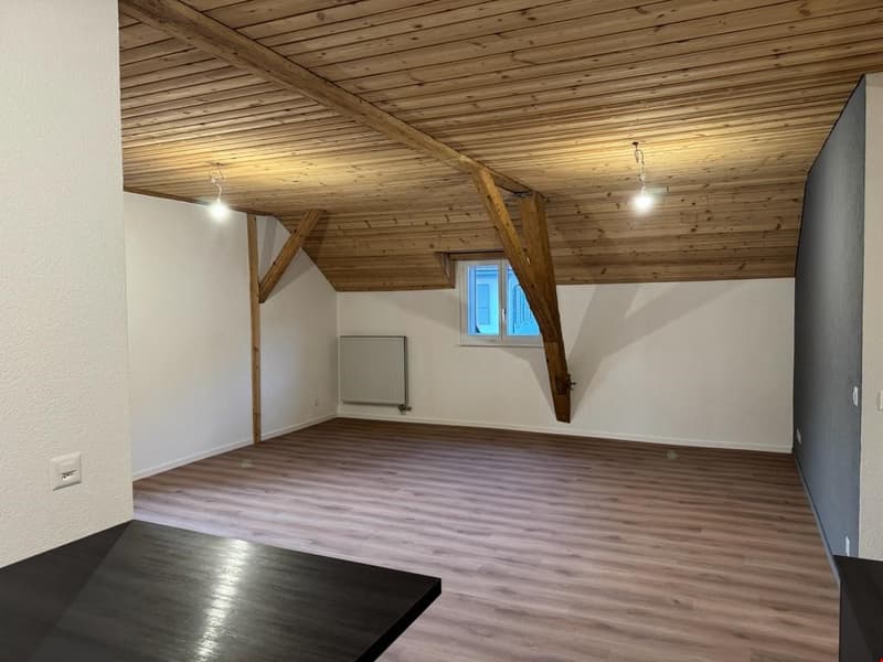 empty room, wooden floor, wooden beams, window, power outlet, radiator