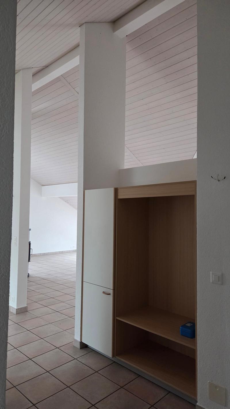 an empty room with a tiled floor, wooden shelves, a closet, and white ceiling