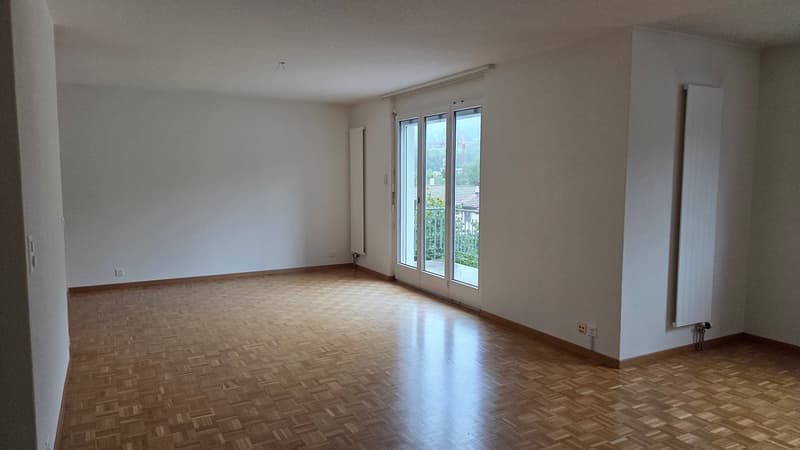 Empty room, wooden floors, sliding glass door, balcony, white walls