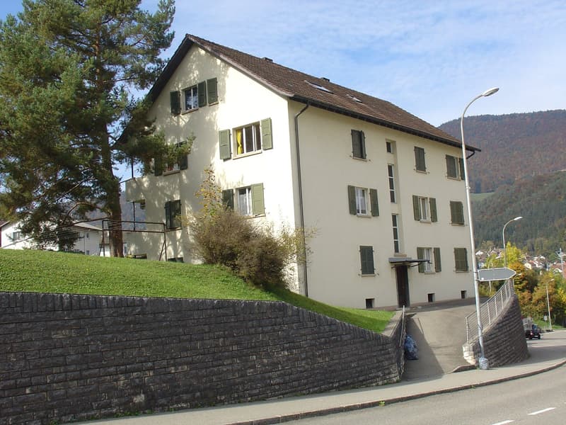 3 story house, white walls, brown roof, multiple windows, brick wall, driveway, street light
