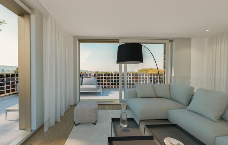 A large living room with a white sofa, gray ottoman, a table with a vase, a large floor lamp, white curtains, wooden floor, and glass doors to a balcony