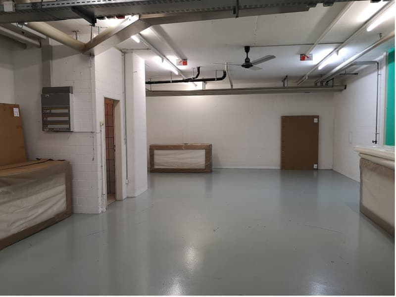 empty room, cement floor, white walls, ceiling fan, open doors, covered items
