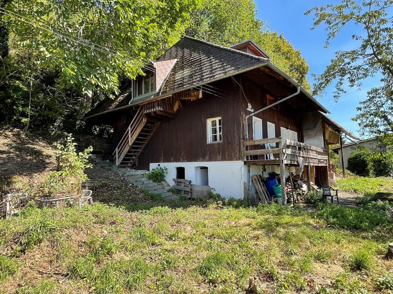 wooden house, wooden staircase, wooden porch, multiple windows, surrounded by grass and trees