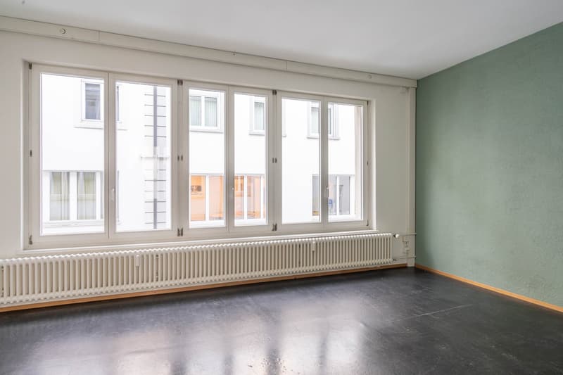 empty room, large windows, white radiator, black floor