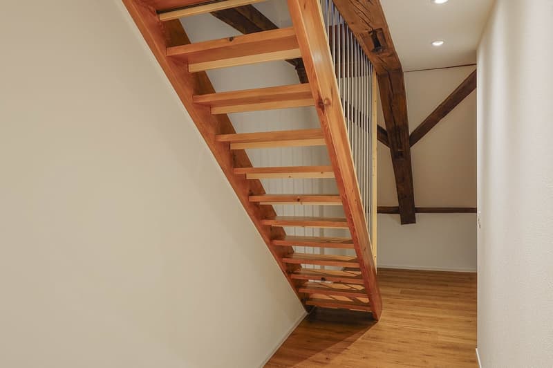 Wooden staircase, wooden steps, white walls, wooden beams, tiled floor