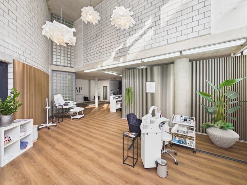 Interior design with white walls, wooden floor, multiple white chairs, lamps, desk, plants