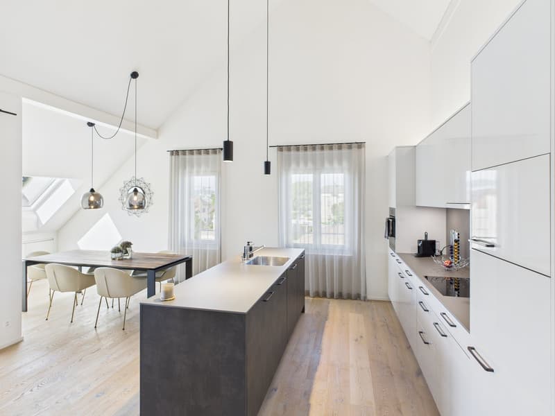modern kitchen with island, white cabinets, wooden floor, pendant lights, dining table, chairs