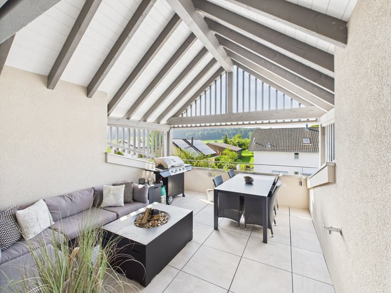 covered balcony with dining table, sofa, fire pit, grill, and scenic view