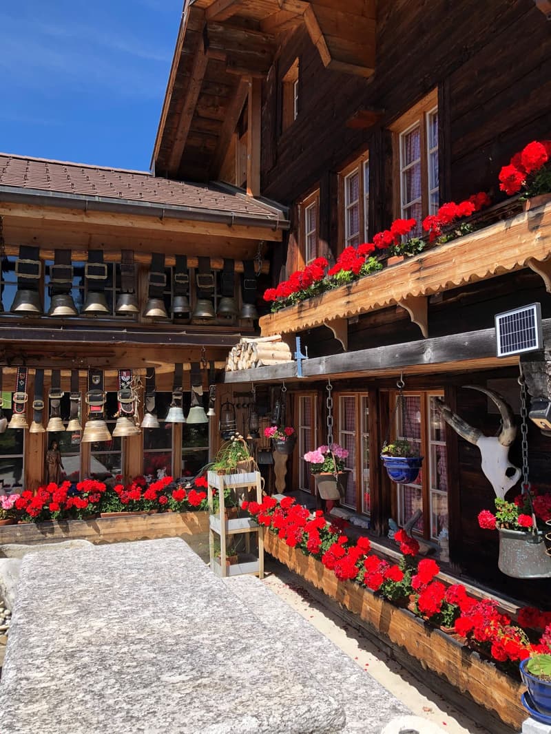 wooden exterior, red flowers, red roof, bells hanging on the exterior
