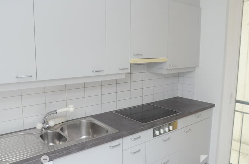 White cabinets, granite countertop, stainless steel sink, built-in oven, gas stove, and a window