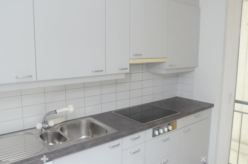 White cabinets, granite countertop, stainless steel sink, built-in oven, gas stove, and a window
