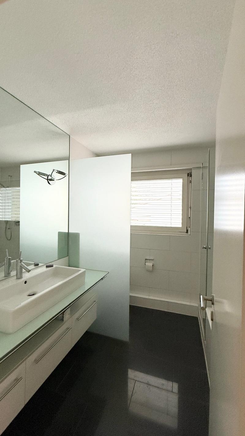modern bathroom, white tiles, white sink, shower, white cabinets, open window