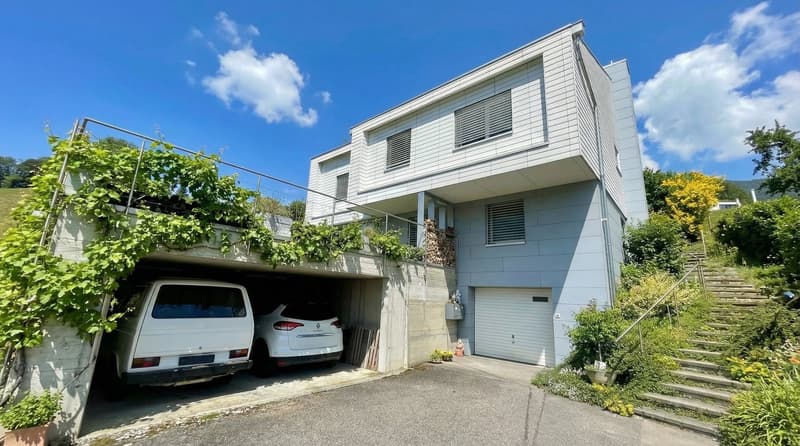 white 2 story house, garage for 2 cars, steps to the entrance, covered parking area, plants on the wall