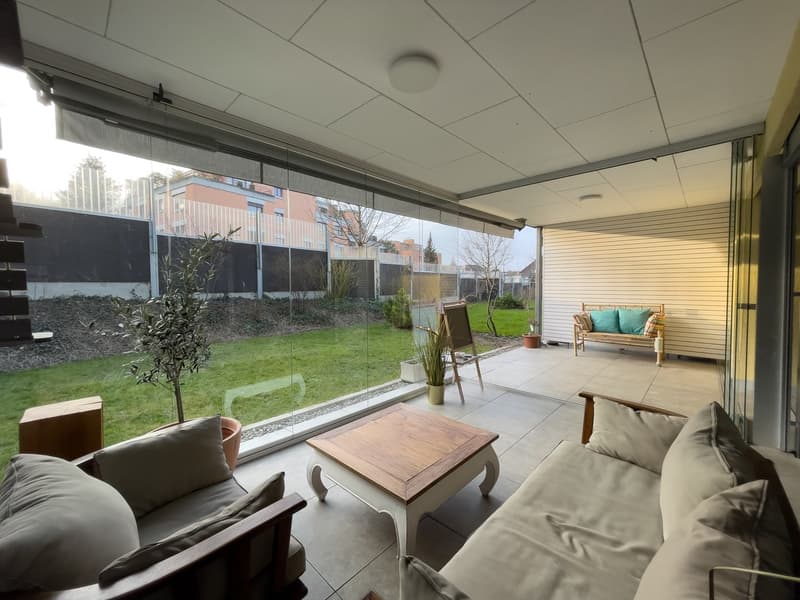 large glass windows, wooden coffee table, two couches, wooden bench, potted plants, wooden chair, tiled floor, outdoor view