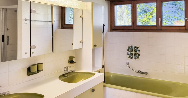 bathroom with double sink, bathtub, window