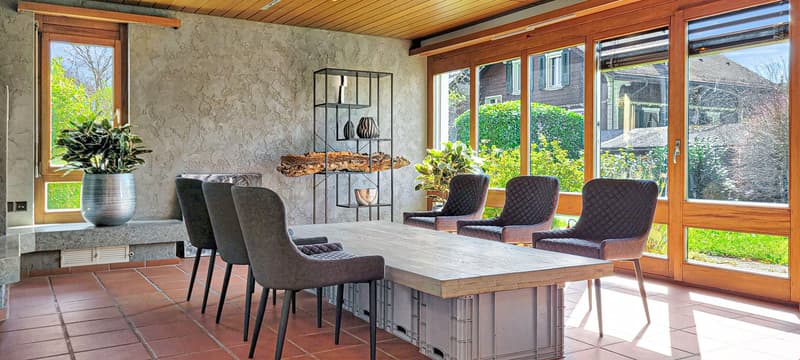 dining room, large table, six chairs, floor to ceiling windows, stone bench, wooden ceiling, greenery
