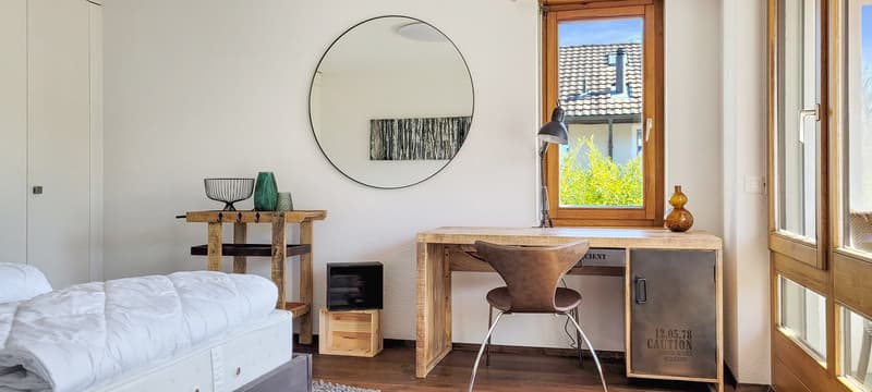 single bed, wooden desk, chair, desk lamp, wooden side table, large mirror, door