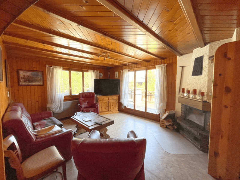 wooden walls, fireplace, red leather couches, wooden coffee table, TV, wooden chair, radiator