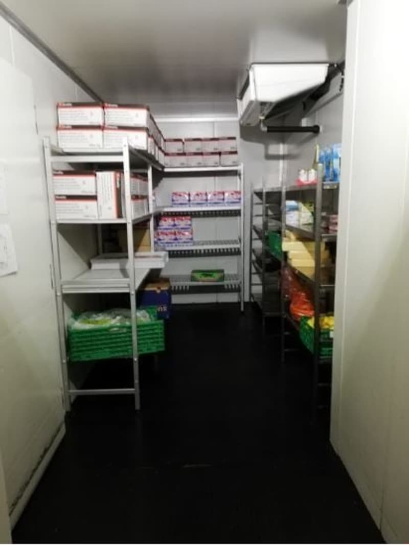 The image shows a storage room or pantry with various shelves and storage containers. The room appears to be well-organized, with different items and supplies neatly arranged on the shelves.