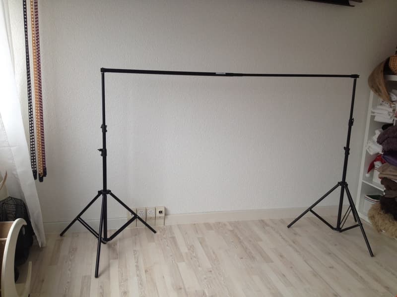 white walls, wooden floor, tripod, curtains, electrical outlet, white shelf
