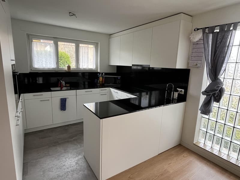 modern kitchen, white cabinets, black countertops, open shelving, wooden floor, large windows, microwave, refrigerator