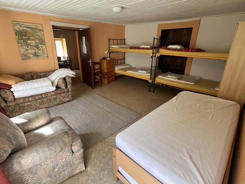 three bunk beds, couch, wooden chair, nightstand, lamp, carpet, picture frame, wooden bed