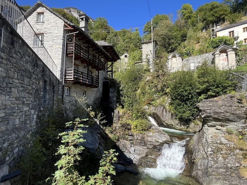 stone house, wooden balcony, waterfall, stream, mountains