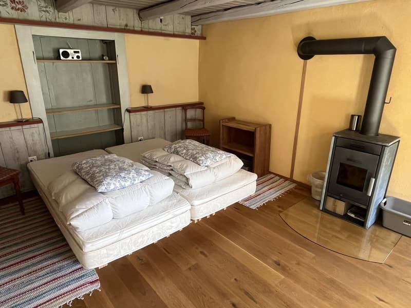 yellow wall, wooden floor, fireplace, stacked beds, shelves, chair, small desk