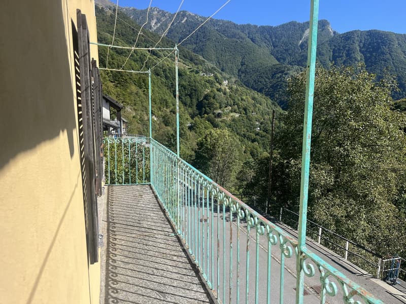 a balcony with a railing that offers a stunning view of the mountains and greenery