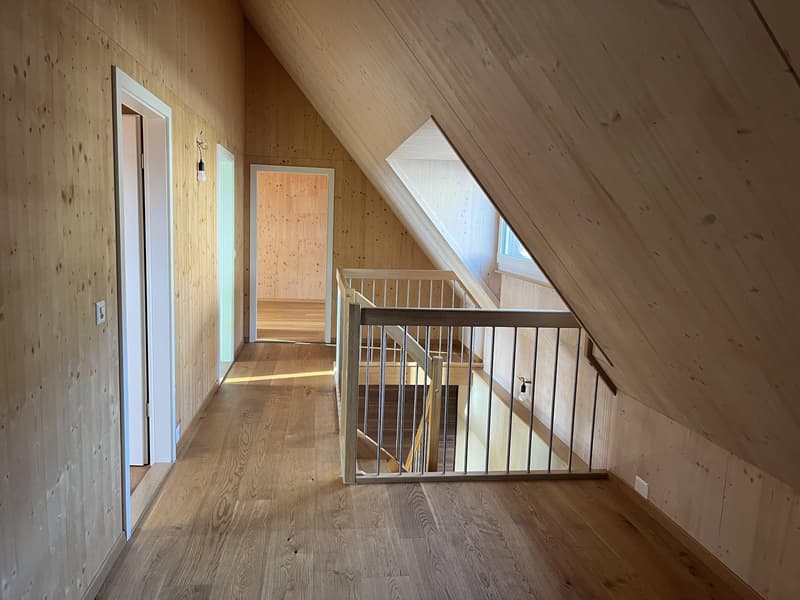Wooden walls, wooden floors, staircase with railings, small hallway, slanted ceiling