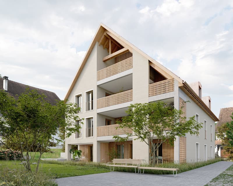 3-story apartment building with a modern, minimalist design. The building features a mix of concrete and wood materials, with large balconies on each floor. The building is surrounded by greenery and has a paved walkway in the front.