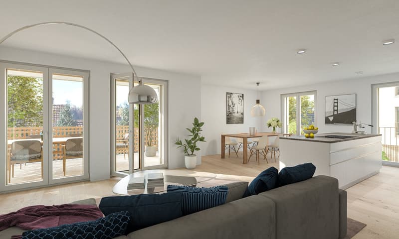 Open concept living room and kitchen, large windows with access to a balcony or terrace, modern furniture including a gray sofa, wooden dining table and chairs, kitchen island with cooktop, pendant lighting, and artwork on the walls.