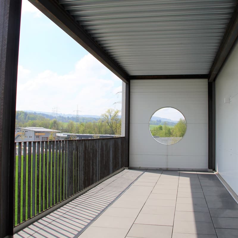 Balcony with metal railing, circular window, tiled floor, metal ceiling