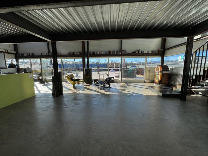 large open space, concrete floor, large windows, modern furniture, metal ceiling