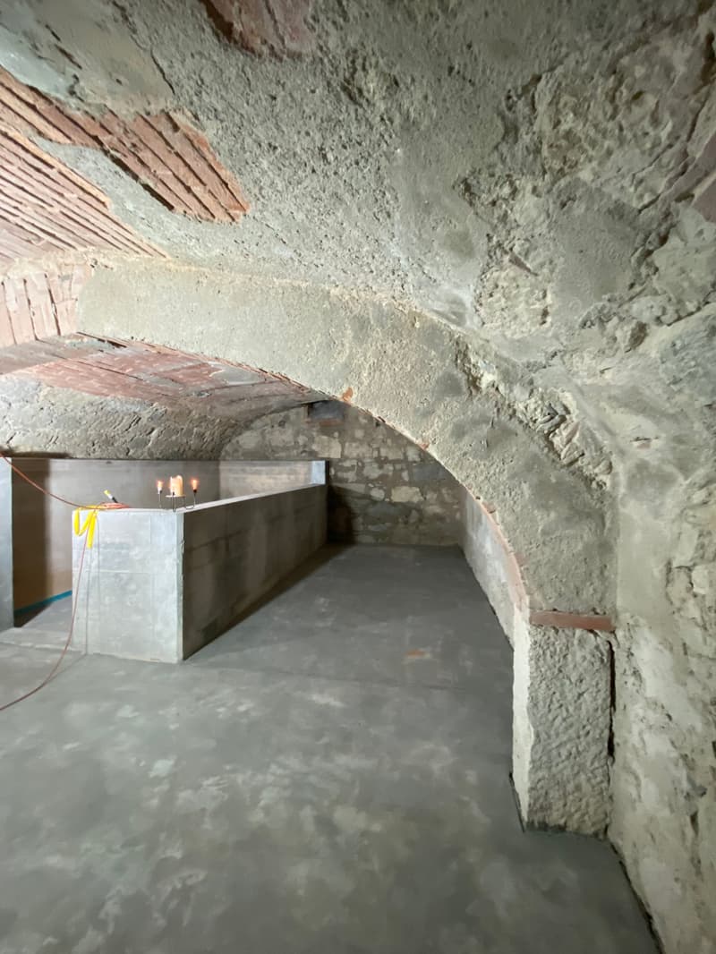 unfinished basement with stone walls, concrete floor, and a concrete counter