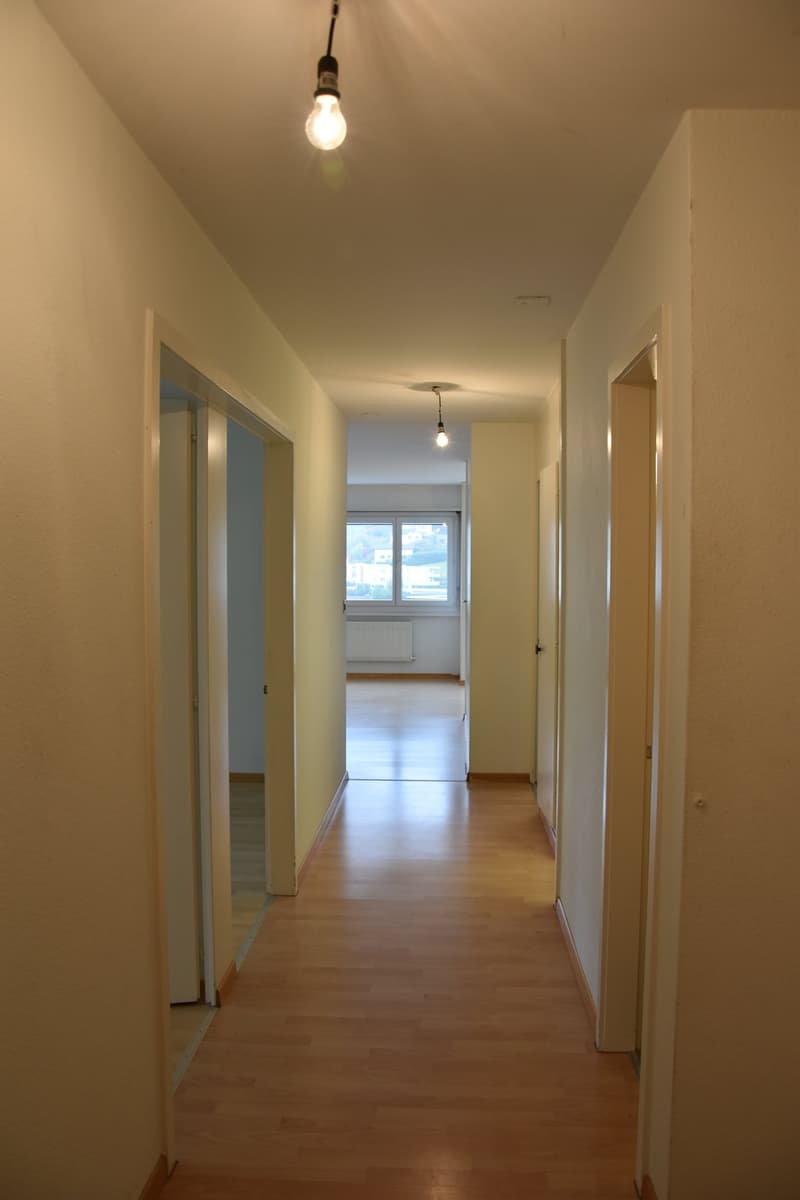 empty hallway, wooden floors, white walls, small windows