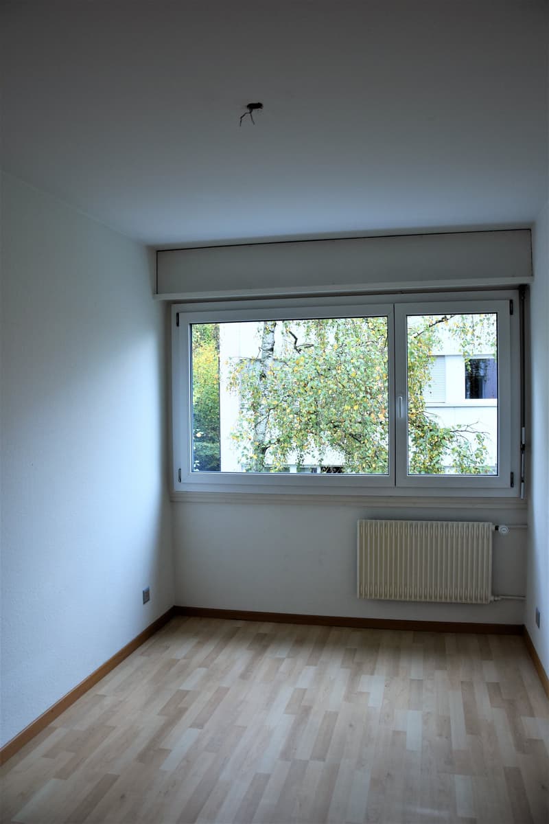 empty room, wooden floor, white walls, large window, white radiator