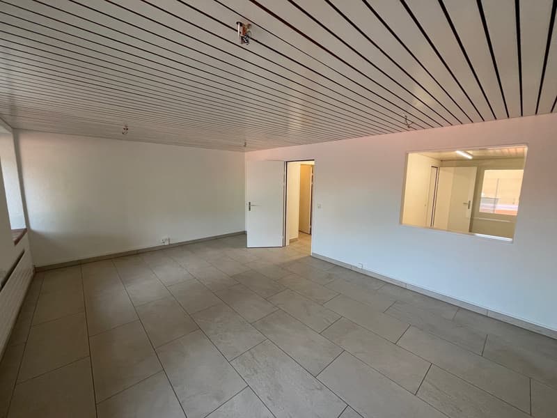 empty room, tile flooring, white walls, white ceiling with horizontal stripes, glass window with door leading to hallway, power outlet and switch on wall