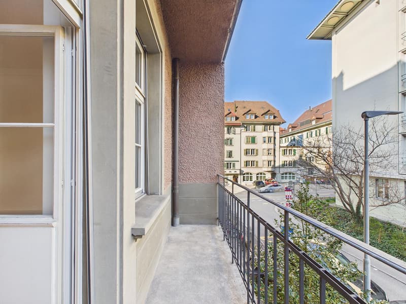 Balcony with railings, concrete floor, glass window, concrete wall, street view