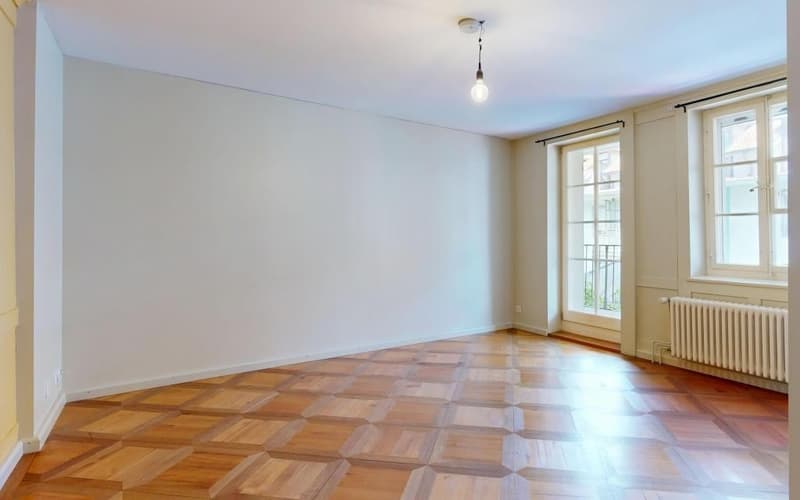empty room, wooden parquet floor, white walls, 2 windows, radiator