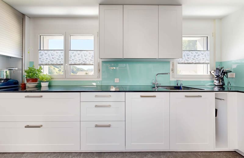 white kitchen, turquoise countertops, modern faucet, windows, electrical outlets, potted plants, kitchen utensils