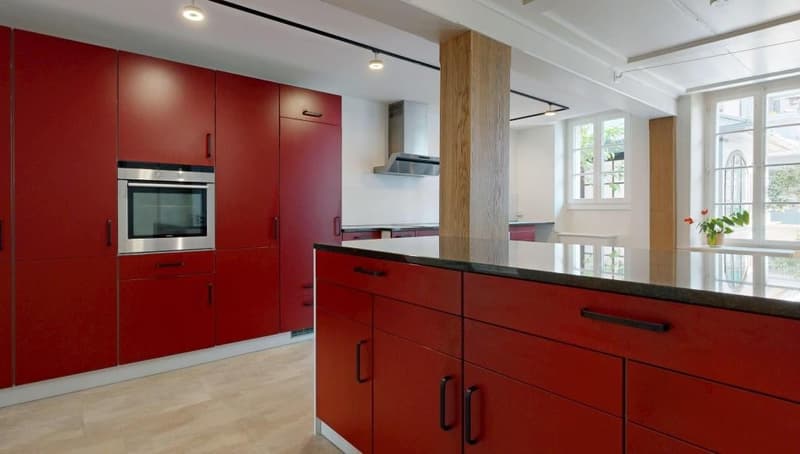 modern kitchen with red cabinets, stainless steel oven, granite countertop, wooden floor