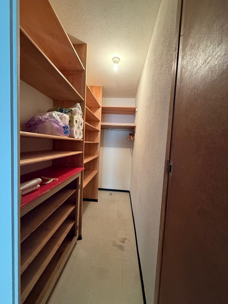 Wooden shelves, storage area, clothes rack, small light fixture