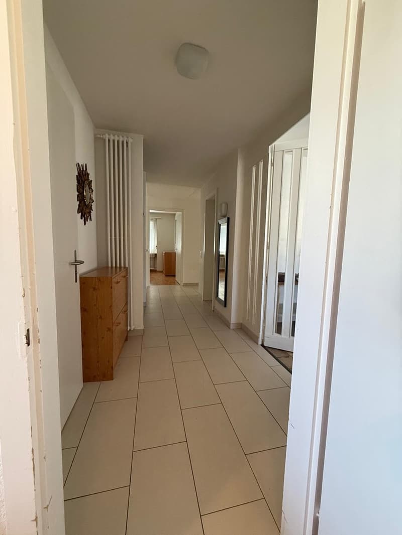 tiled floor, wooden cabinet, white ceiling, hallway