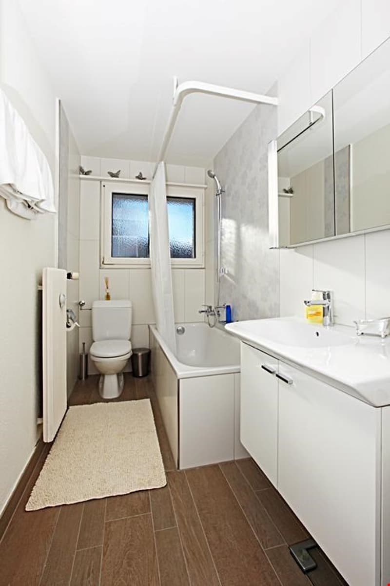 Modernes Badezimmer mit Badewanne, Lavabo, Spiegelschrank und WC