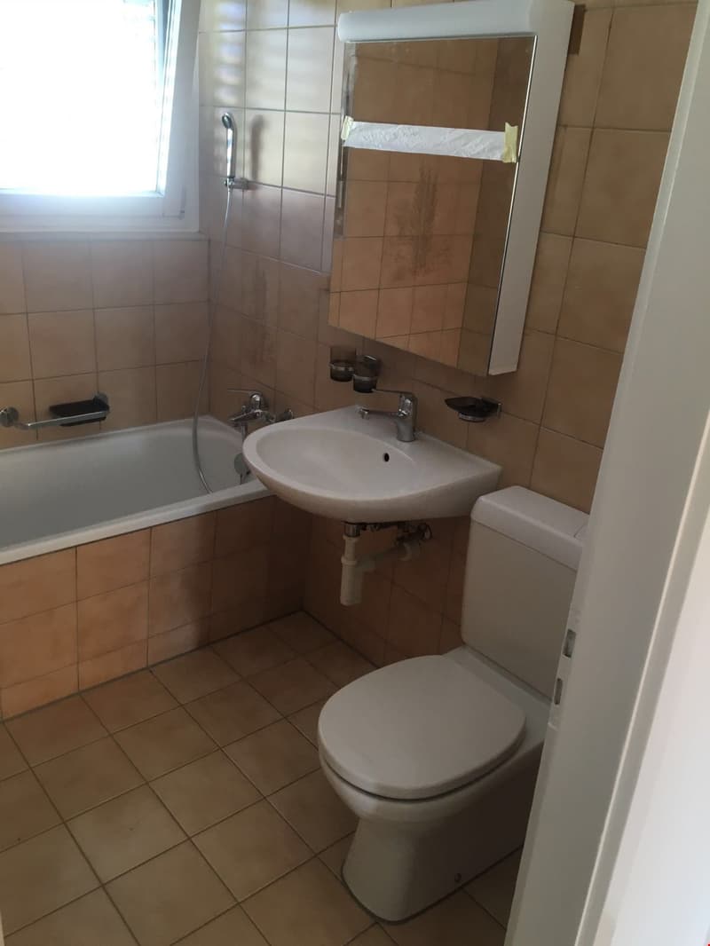 Freundliches, helles Badezimmer mit Badewanne, WC und Lavabo/Spiegelschrank