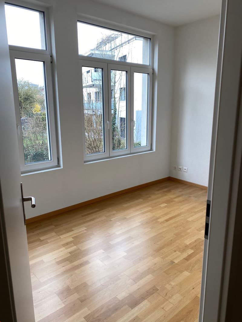 Schlafzimmer mit grossen Fenstern und mit schönem Echtholz Parkett